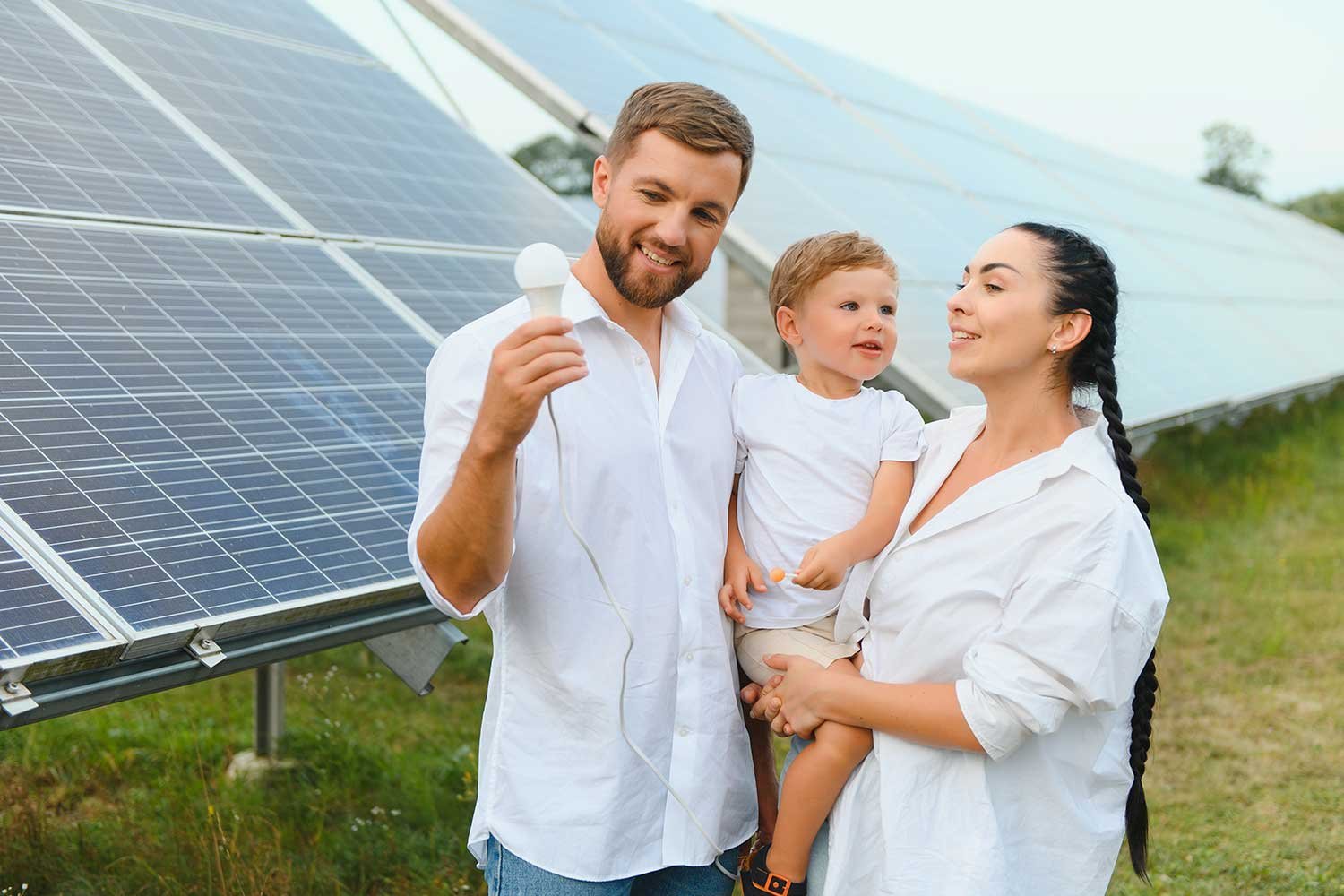 a-young-happy-family-is-standing-near-solar-panels